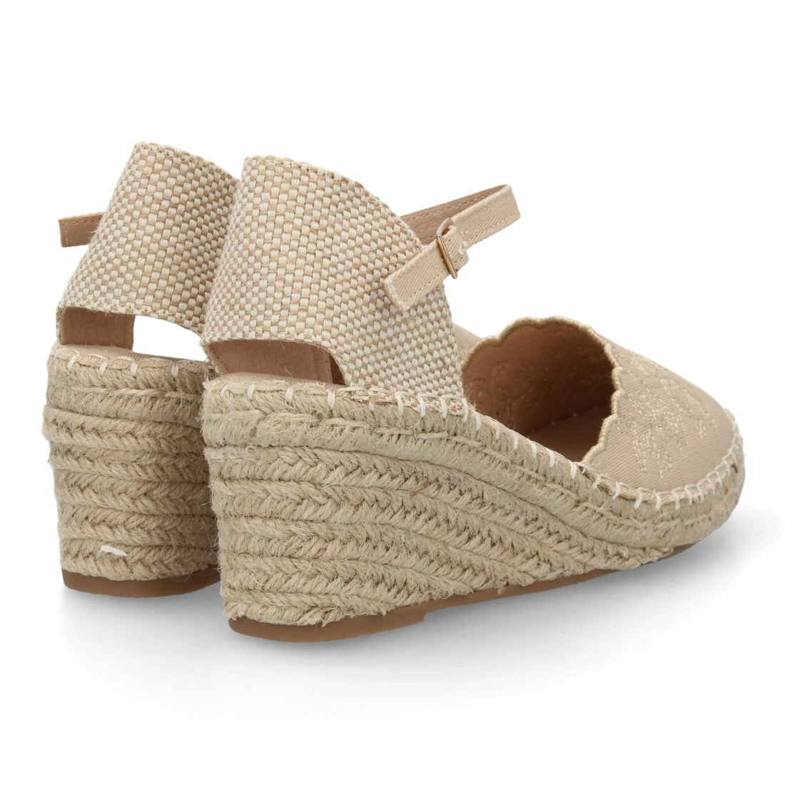 Alpargata cuña beige con bordado floral y cierre de hebilla al tobillo.