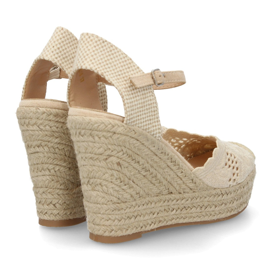 Alpargata beige bordada con cuña de esparto y talón abierto.