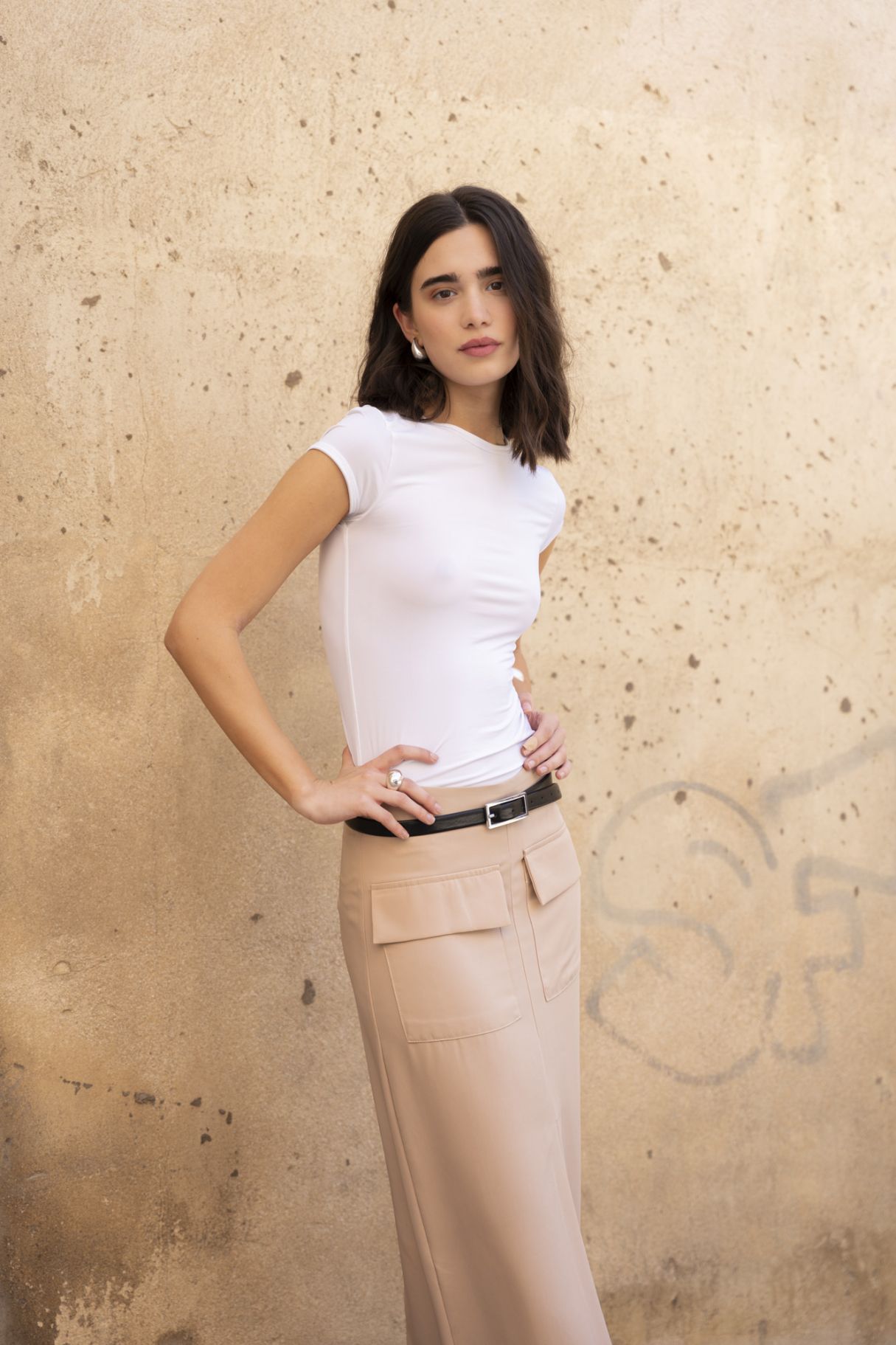 Falda midi para mujer de estilo cargo en color rosa pastel con bolsillos de solapa laterales y abertura frontal.