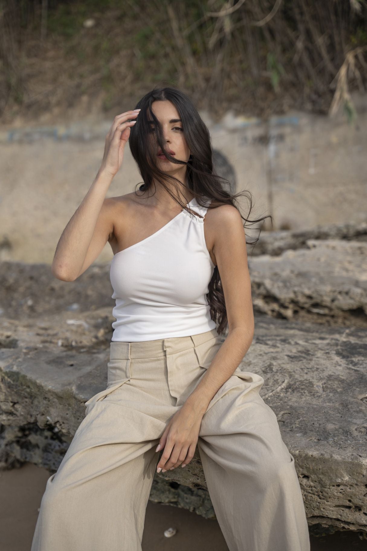 Top corto para mujer en color crudo con diseño asimétrico de un solo hombro y silueta ajustada de fiesta.