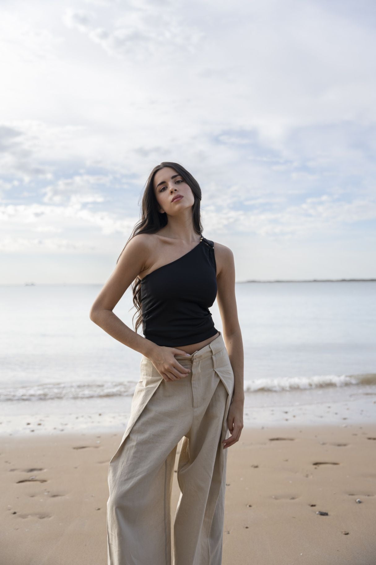 Top corto elástico para mujer en color negro con escote asimétrico de un solo hombro para looks de noche.