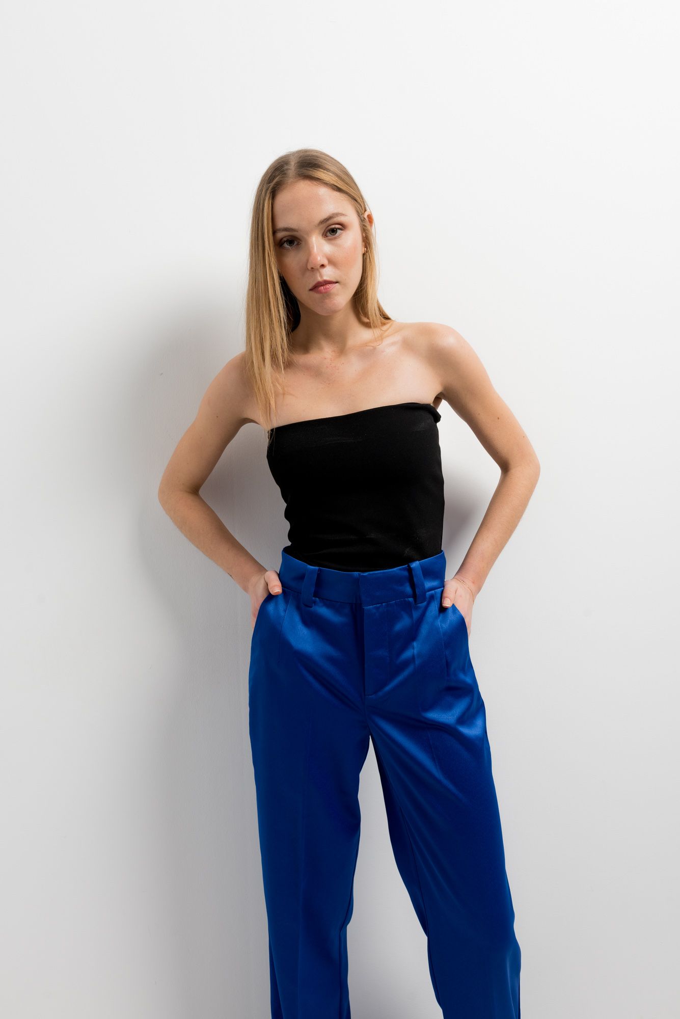 Pantalón fluido de satén azul con brillo sedoso y corte recto.