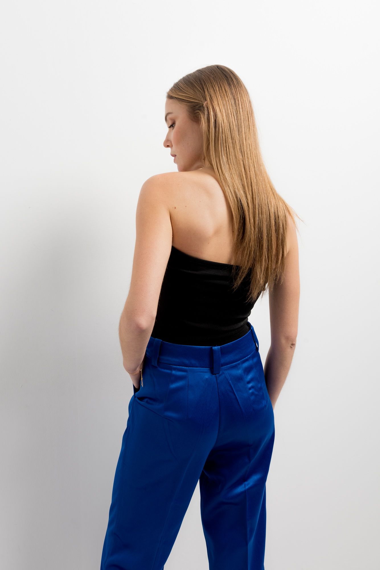 Pantalón fluido de satén azul con brillo sedoso y corte recto.