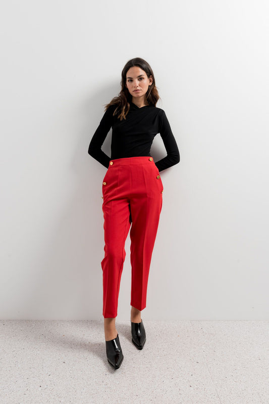 Pantalón rojo de talle alto con fila de botones dorados decorativos.