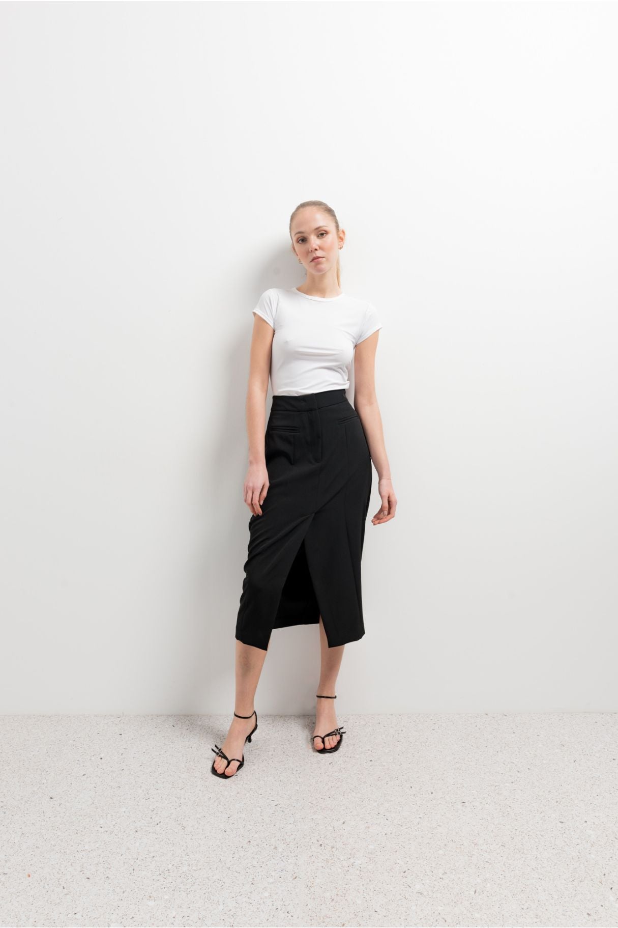 Falda midi de tubo elástica en color negro con abertura lateral en el bajo