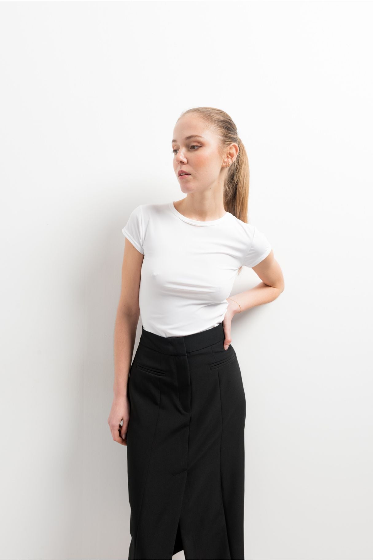 Falda midi de tubo elástica en color negro con abertura lateral en el bajo