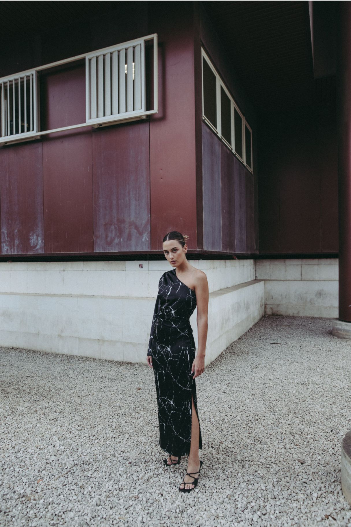 Vestido midi elegante para mujer en color negro con corte asimétrico de un solo hombro y silueta ajustada elástica.