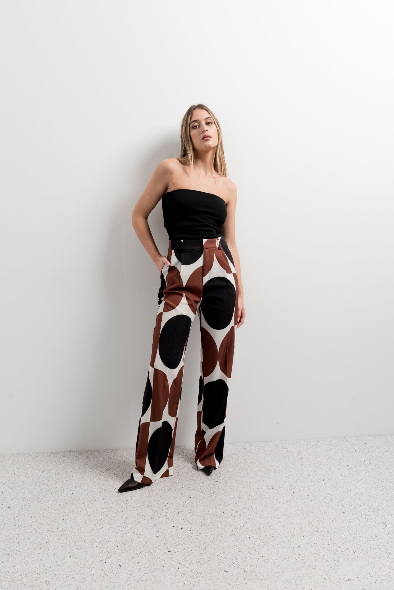 Pantalón recto con diseño geométrico en tonos beige y blanco.