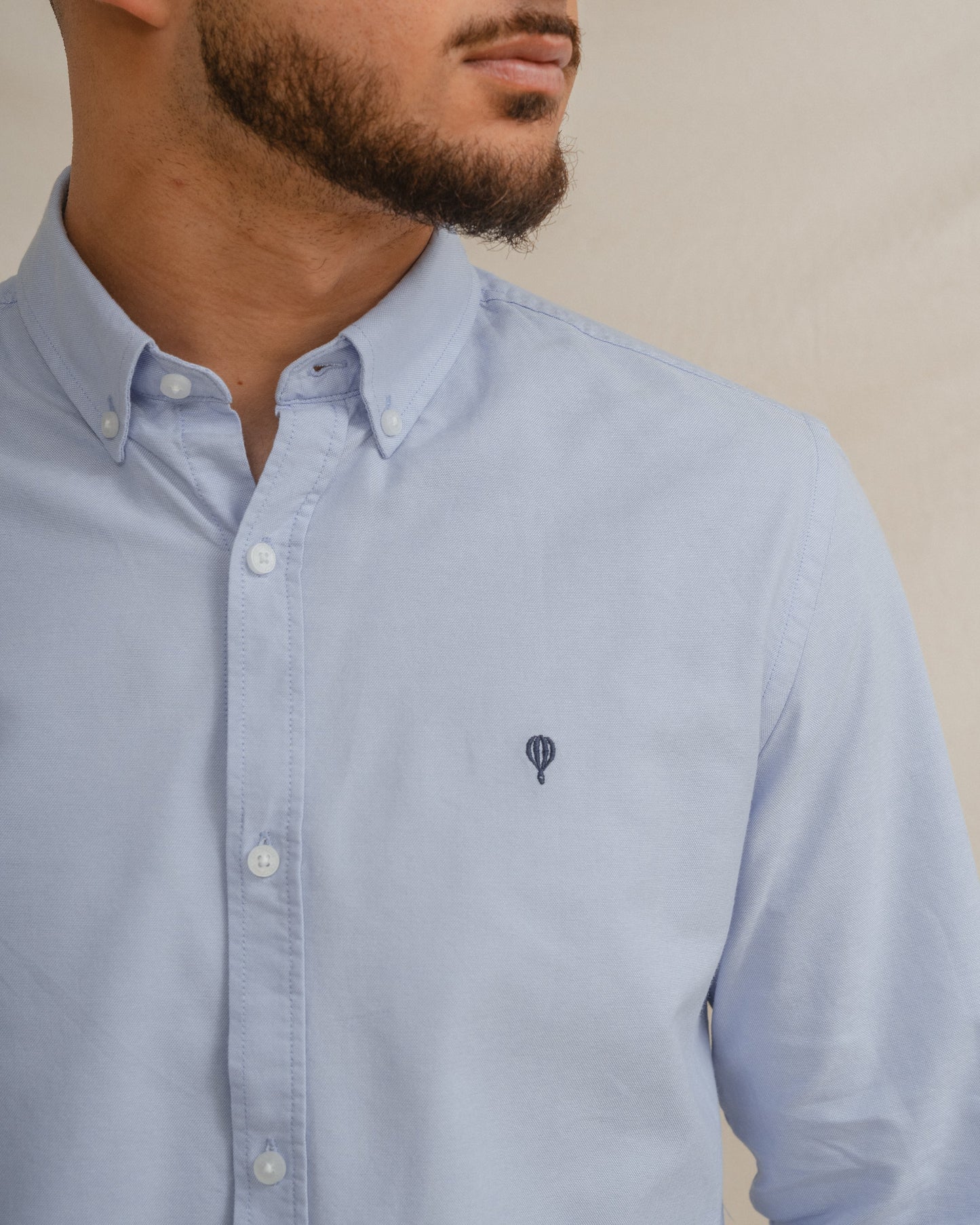 Camisa Oxford azul celeste para hombre con manga larga y detalle de logo.