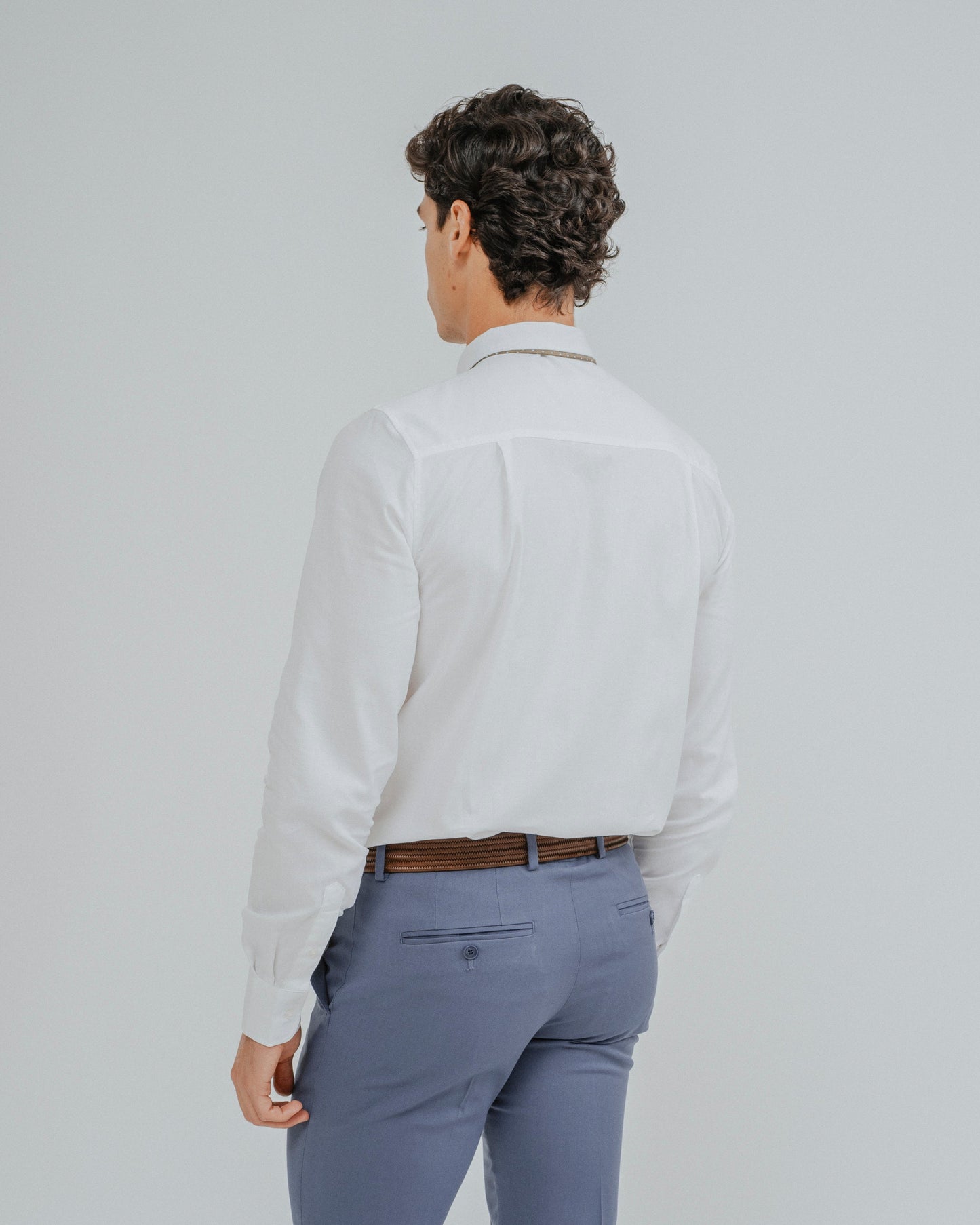 Hombre vistiendo elegante camisa de vestir blanca de algodón con traje formal.