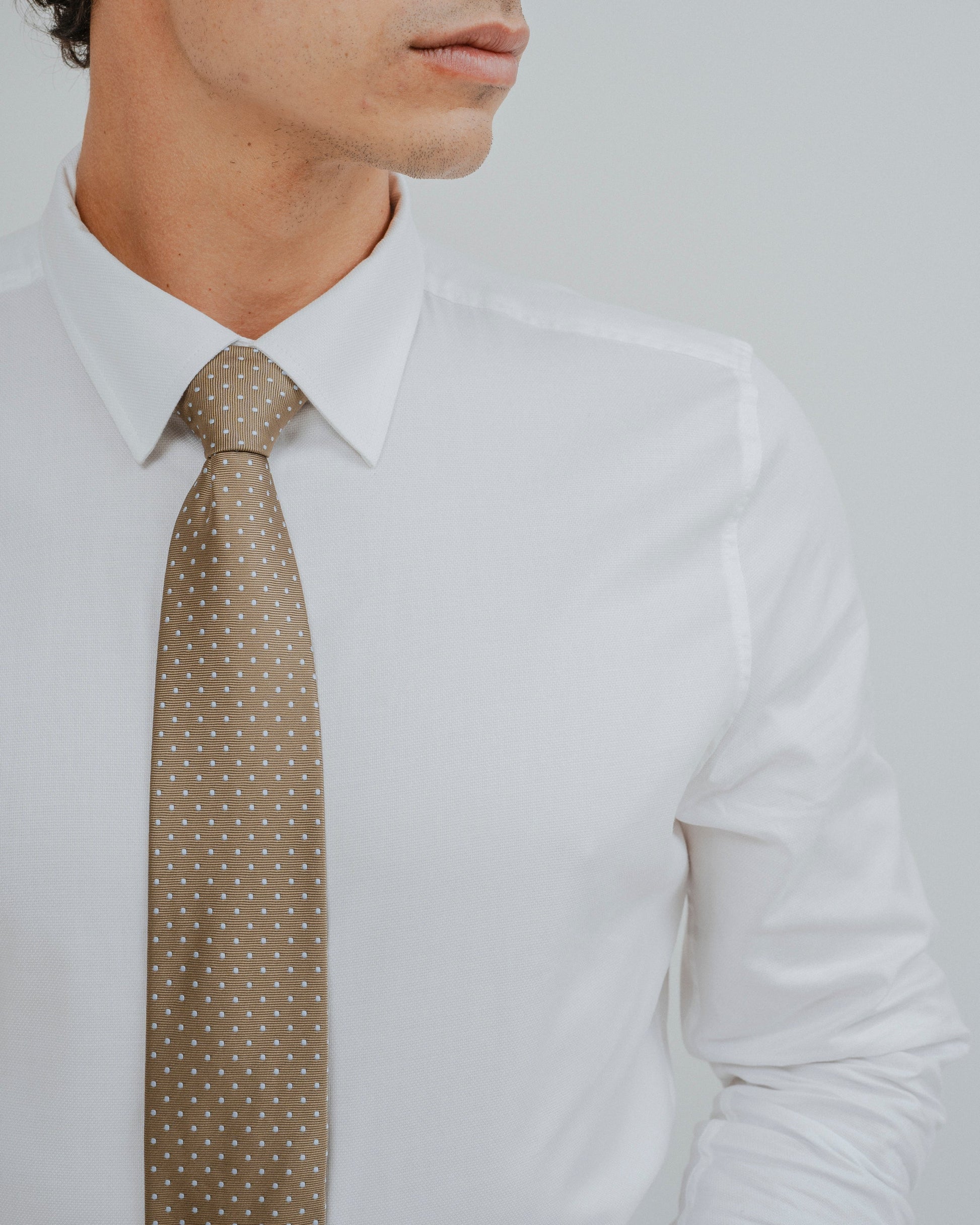 Hombre vistiendo elegante camisa de vestir blanca de algodón con traje formal.