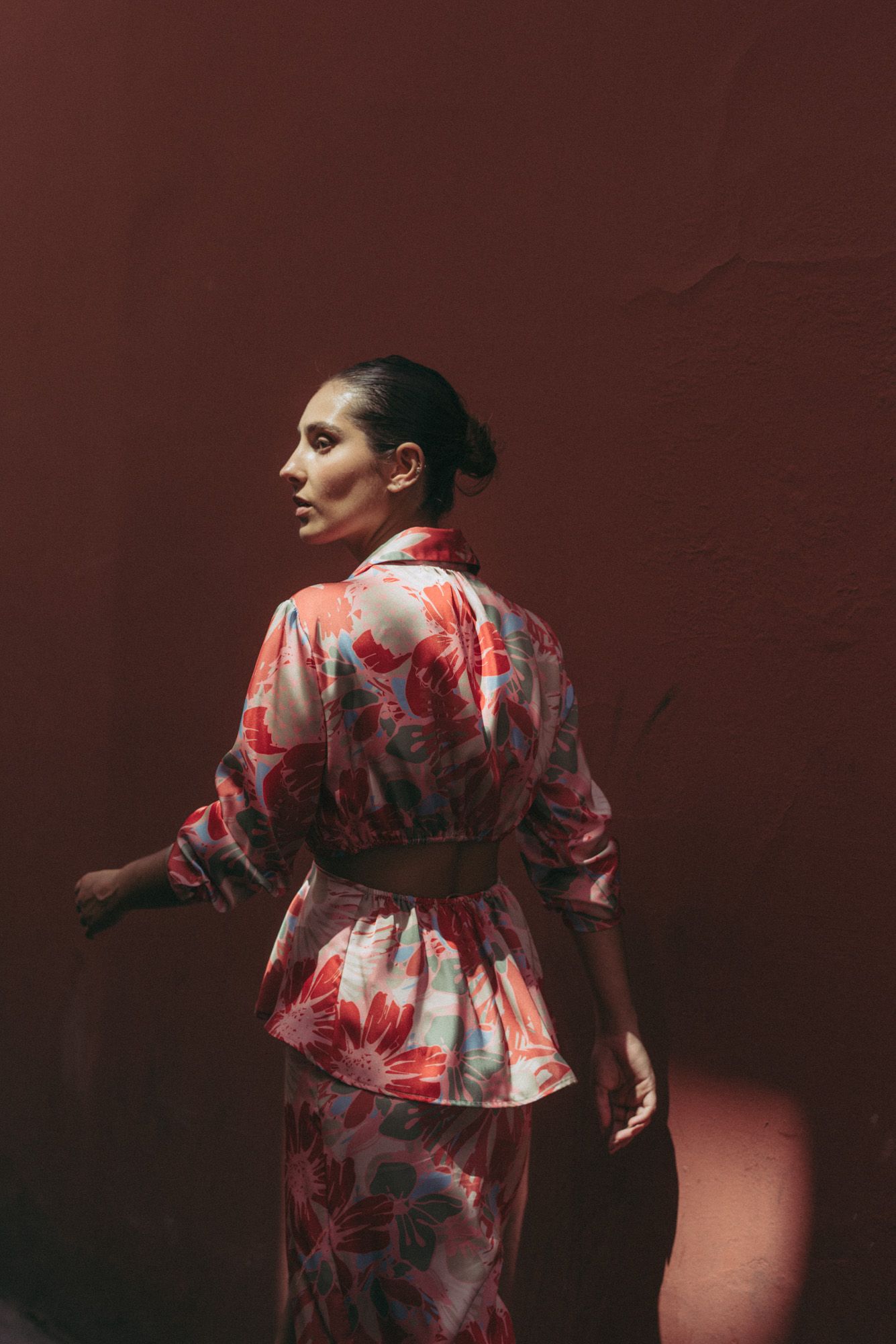 Mujer luciendo camisa blanca con estampado artístico y aberturas en hombros.