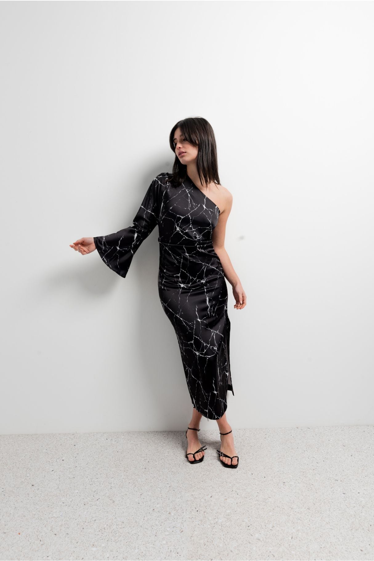 Vestido midi elegante para mujer en color negro con corte asimétrico de un solo hombro y silueta ajustada elástica.