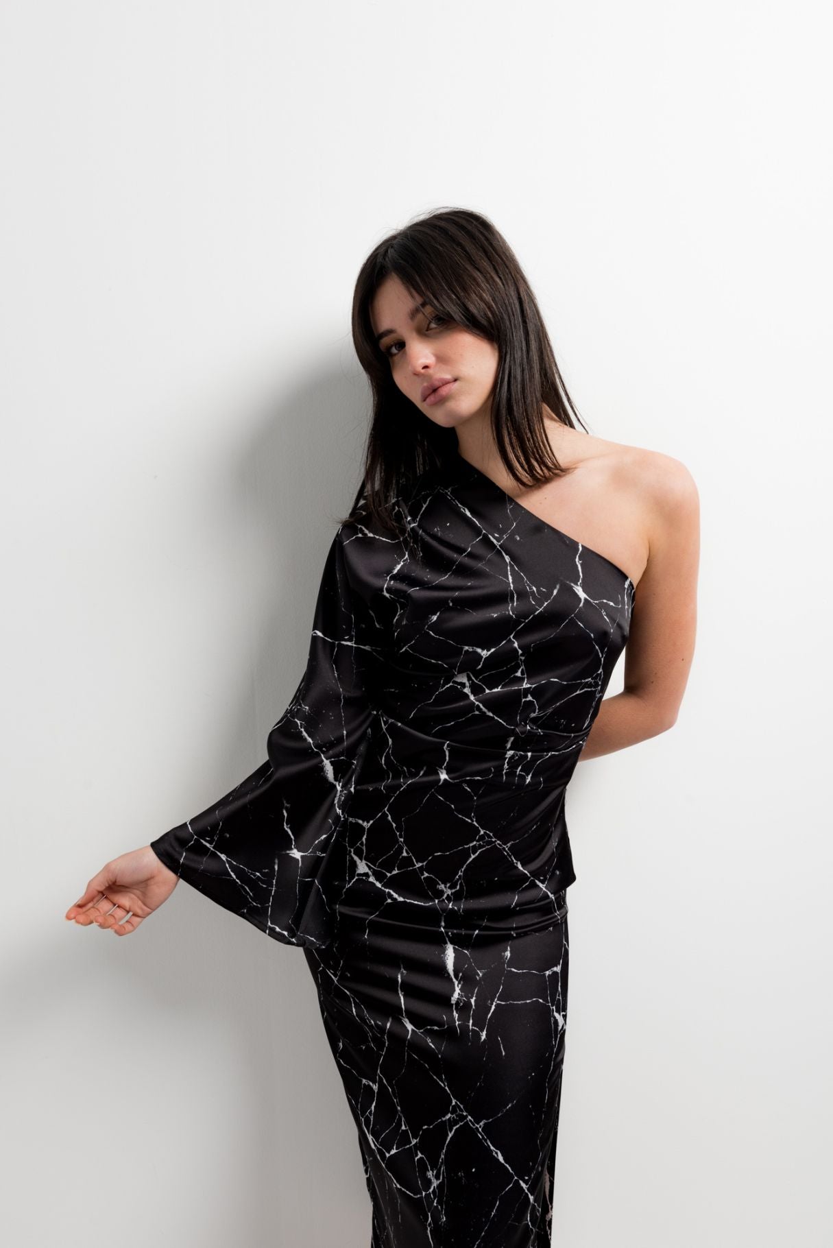 Vestido midi elegante para mujer en color negro con corte asimétrico de un solo hombro y silueta ajustada elástica.