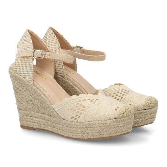 Alpargata beige bordada con cuña de esparto y talón abierto.