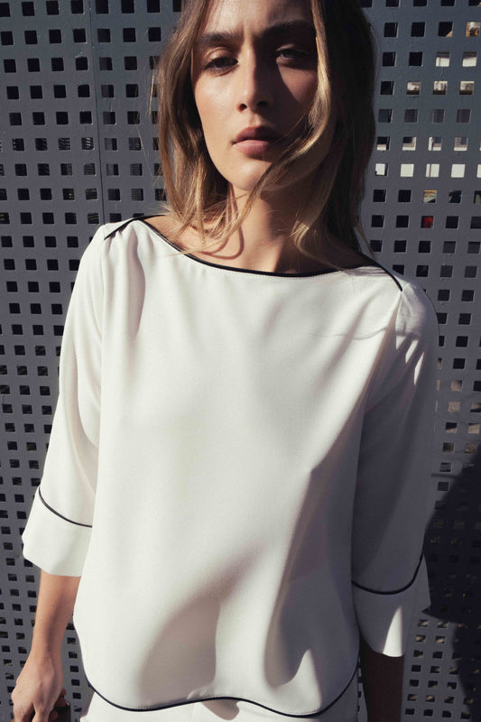 Blusa blanca cuello barco con detalles de vivos negros a contraste