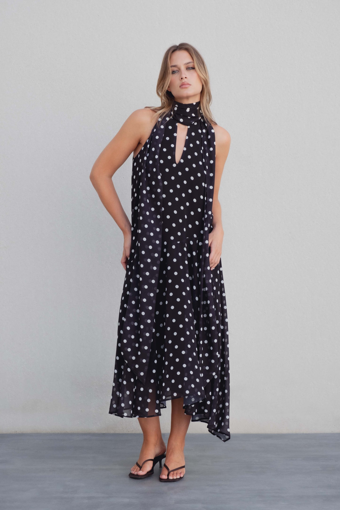 Vestido negro con lunares blancos, cuello halter y bajo asimétrico