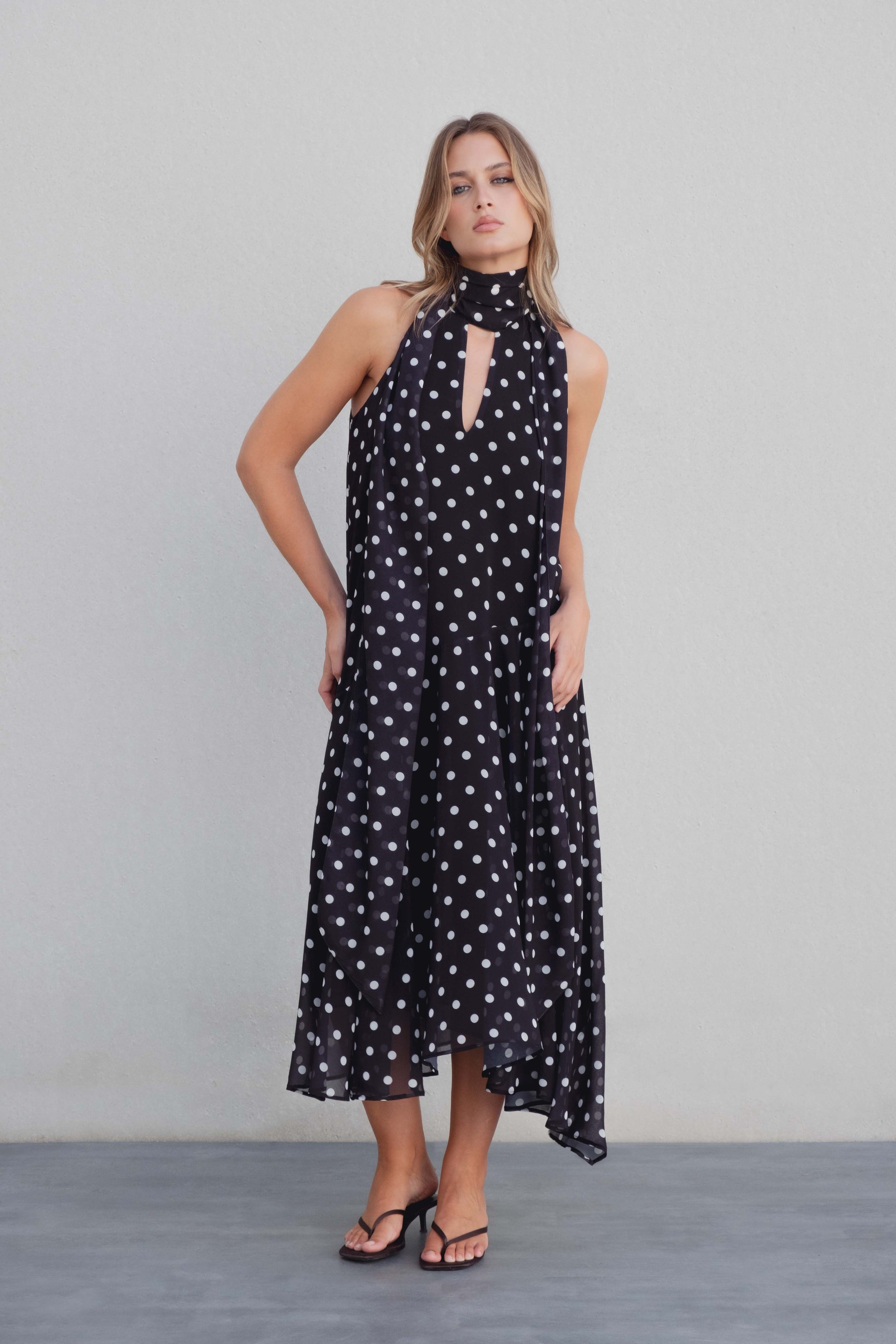 Vestido negro con lunares blancos, cuello halter y bajo asimétrico