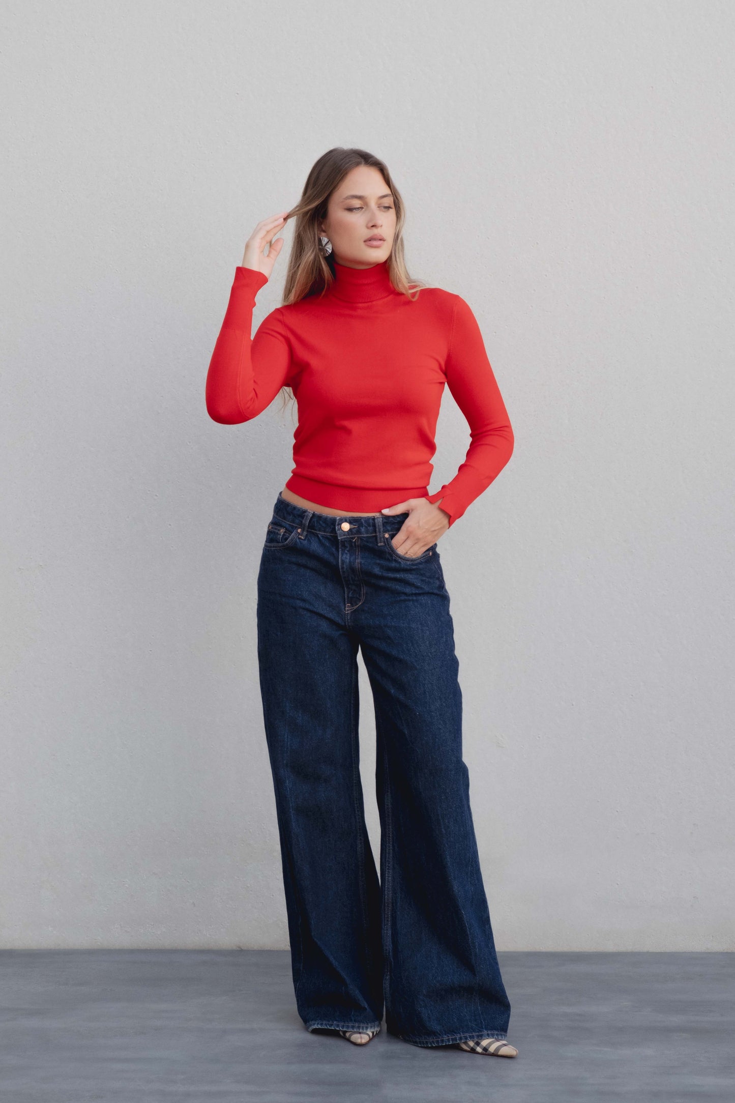 Jersey de punto básico y liso con cuello subido en color (especificar color).