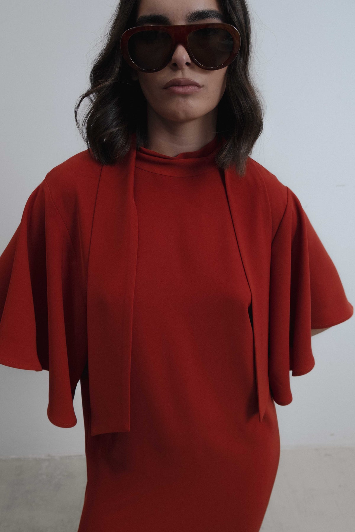Vestido midi fluido elegante con cuello alto y mangas cortas tipo capa