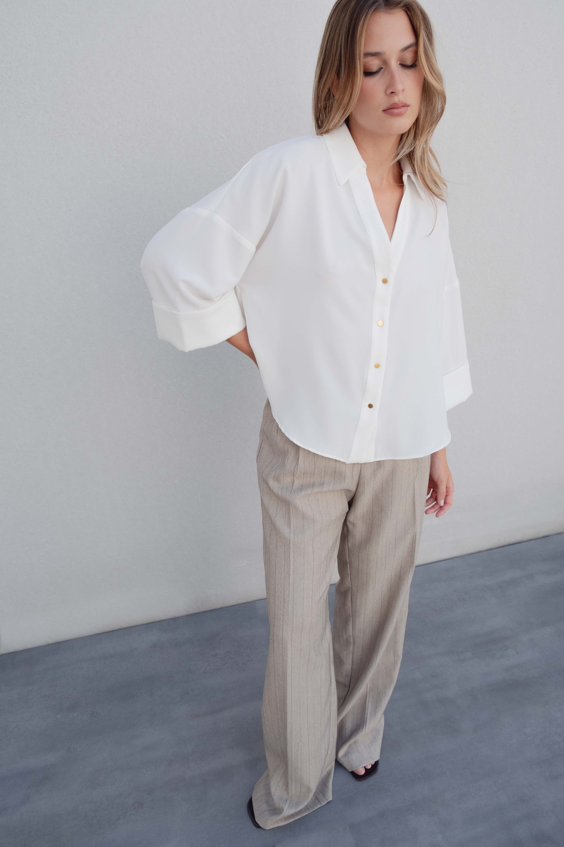 Camisa clásica blanca de manga larga con opción de vuelta. Cierre frontal de botones ocultos y cuello sastre. 95% Poliéster.