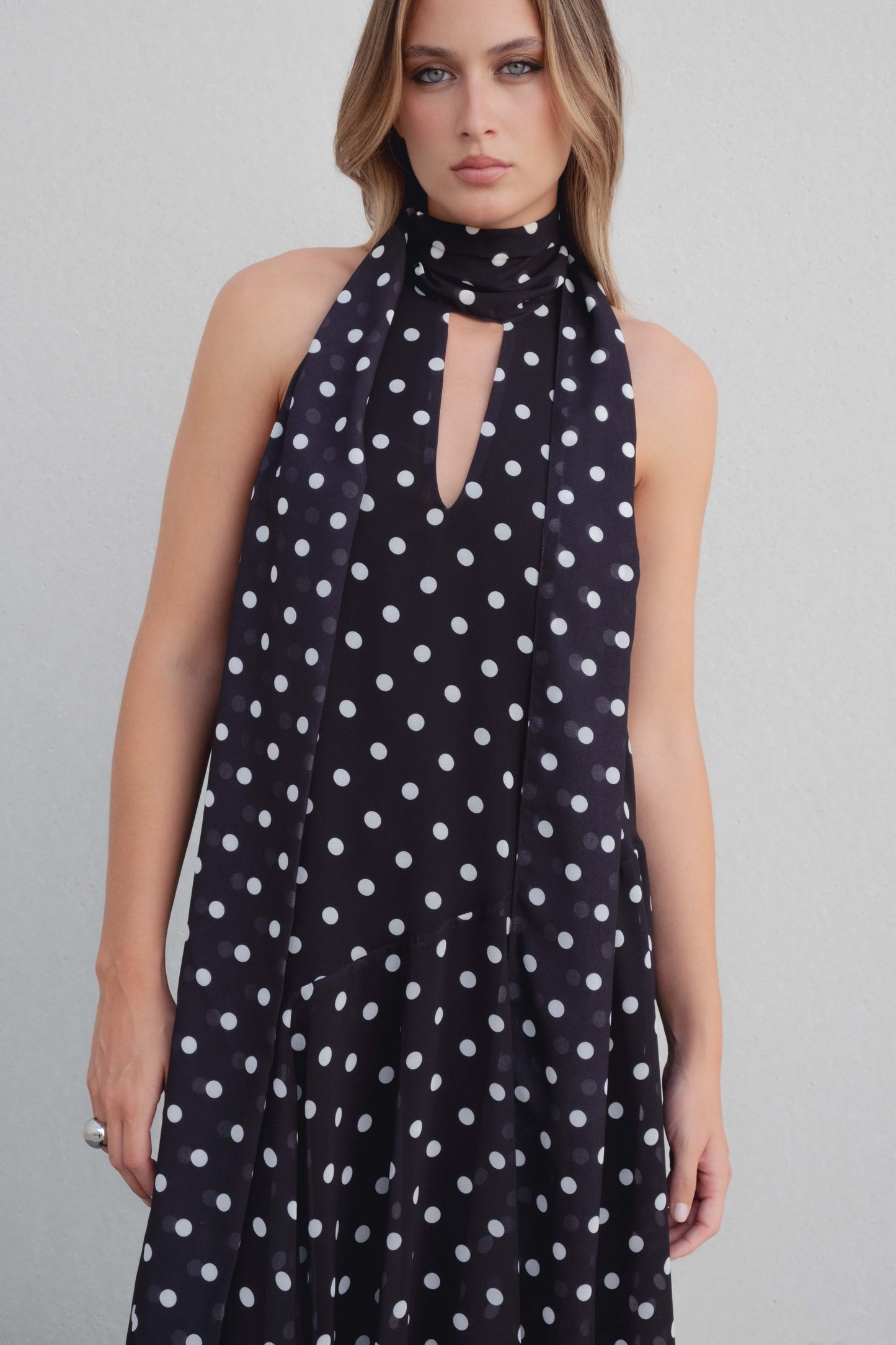 Vestido negro con lunares blancos, cuello halter y bajo asimétrico
