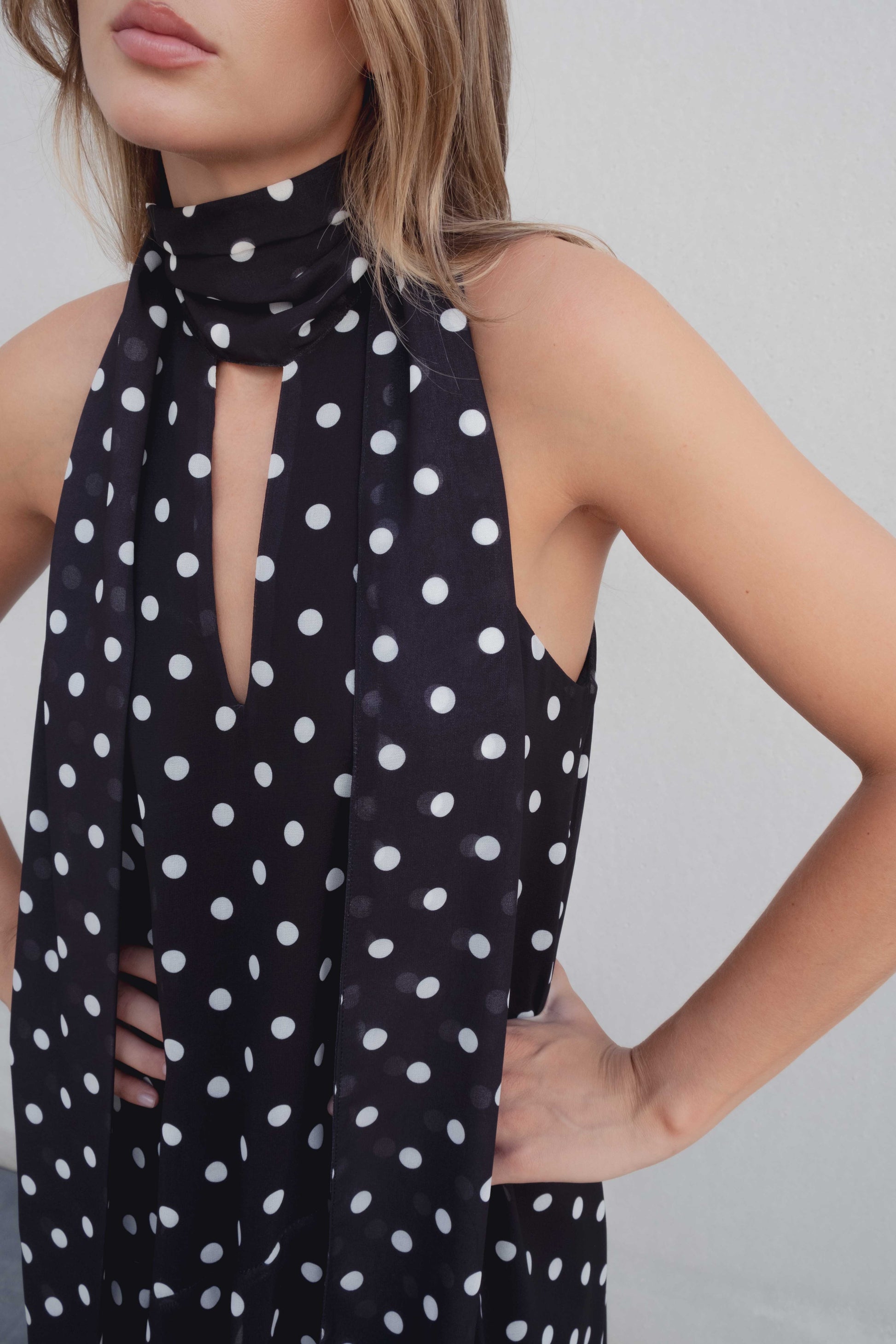 Vestido negro con lunares blancos, cuello halter y bajo asimétrico