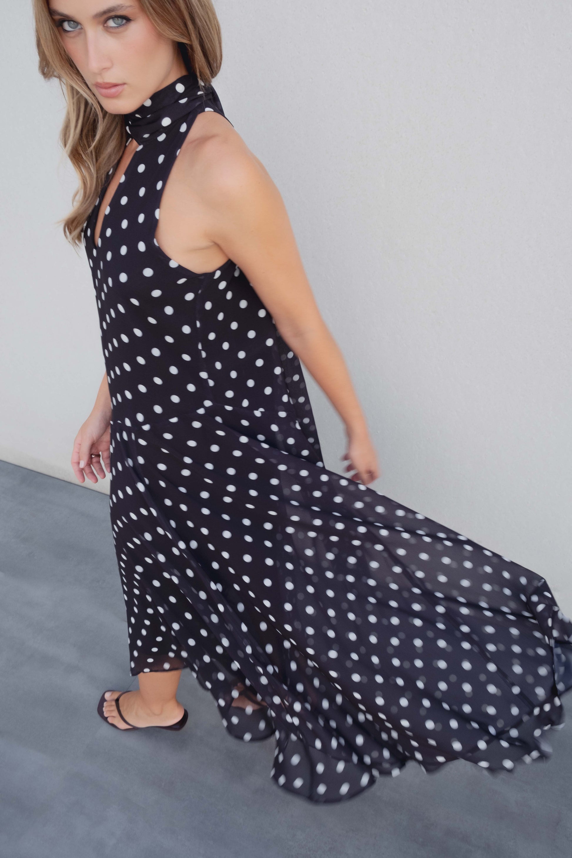 Vestido midi halter con estampado de lunares negros y blancos. Escote corazón y espalda descubierta. Ideal para eventos de verano.