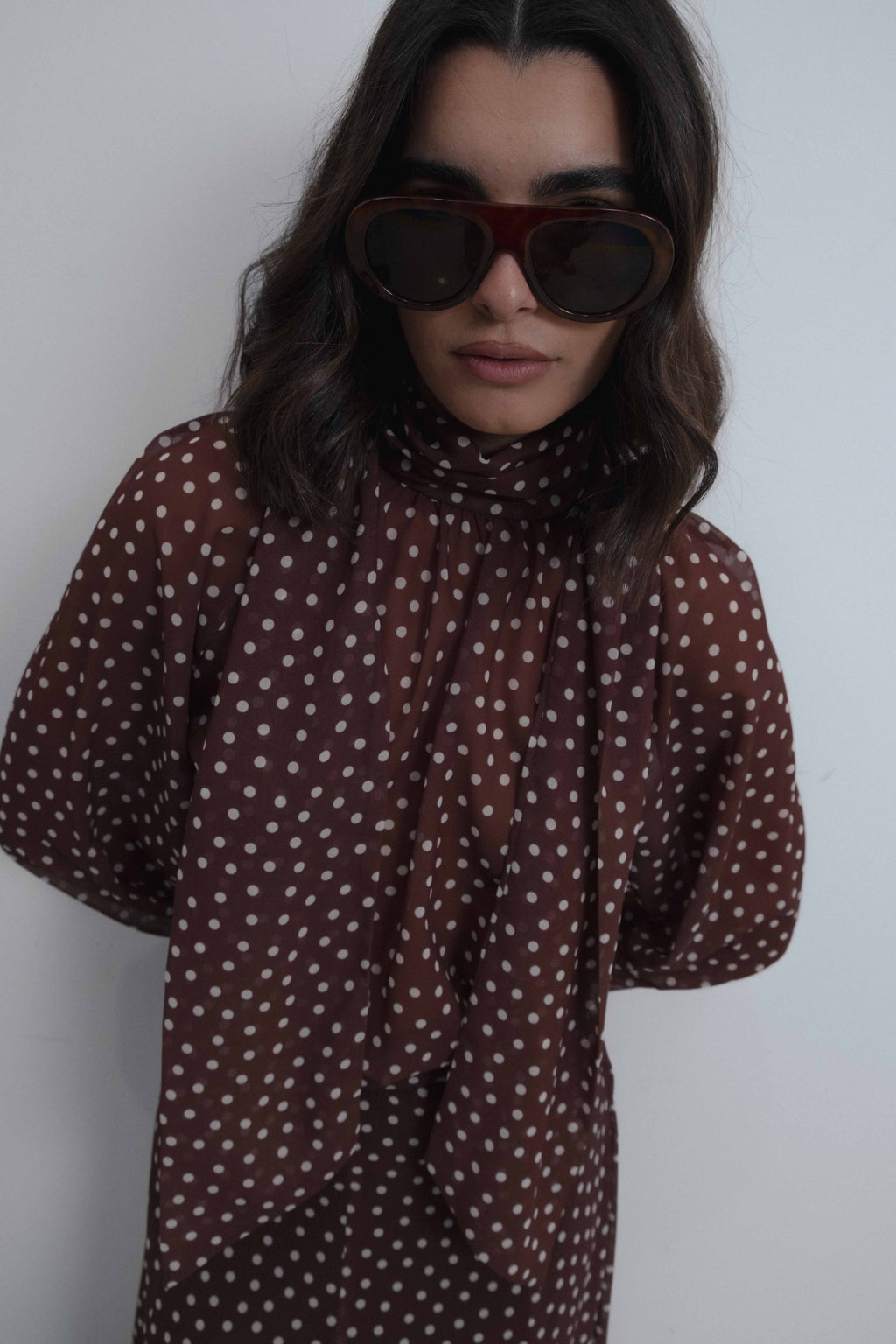 Blusa de lunares con cuello subido y lazo decorativo en la espalda