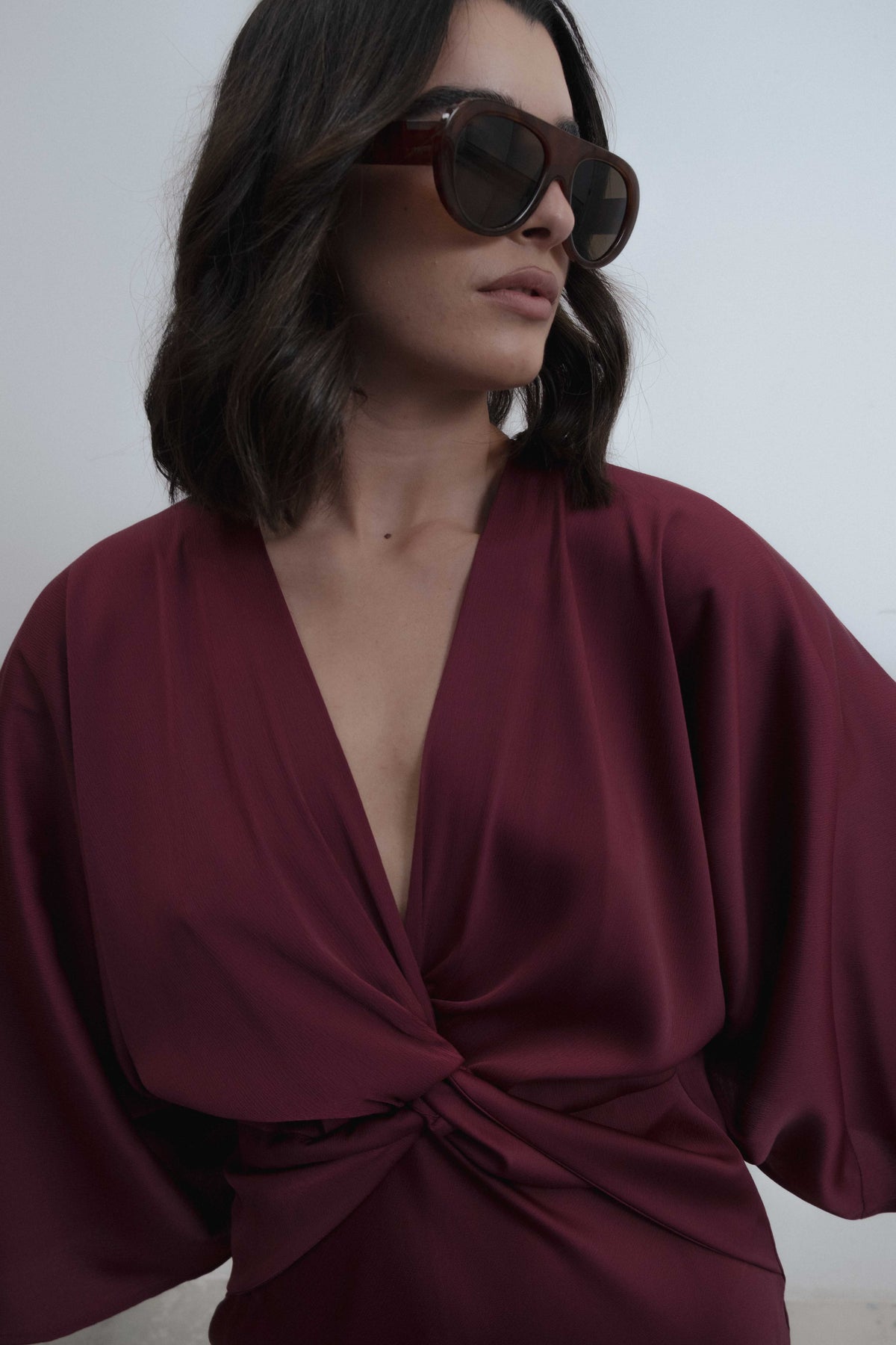 Vestido midi satinado con escote en pico, manga murciélago y detalle de nudo