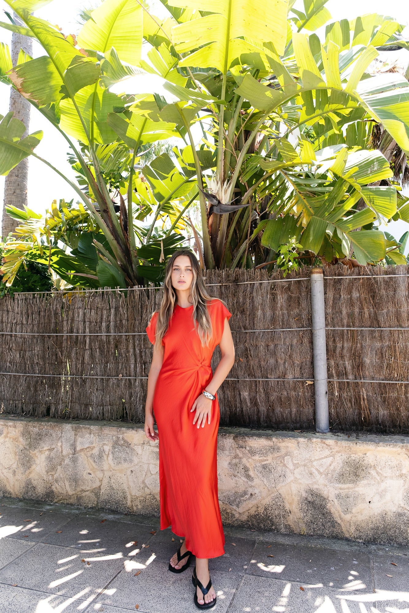 Vestido midi verde esmeralda con nudo en el delantero. Frunces que estilizan y manga corta. Cierre de cremallera en espalda.