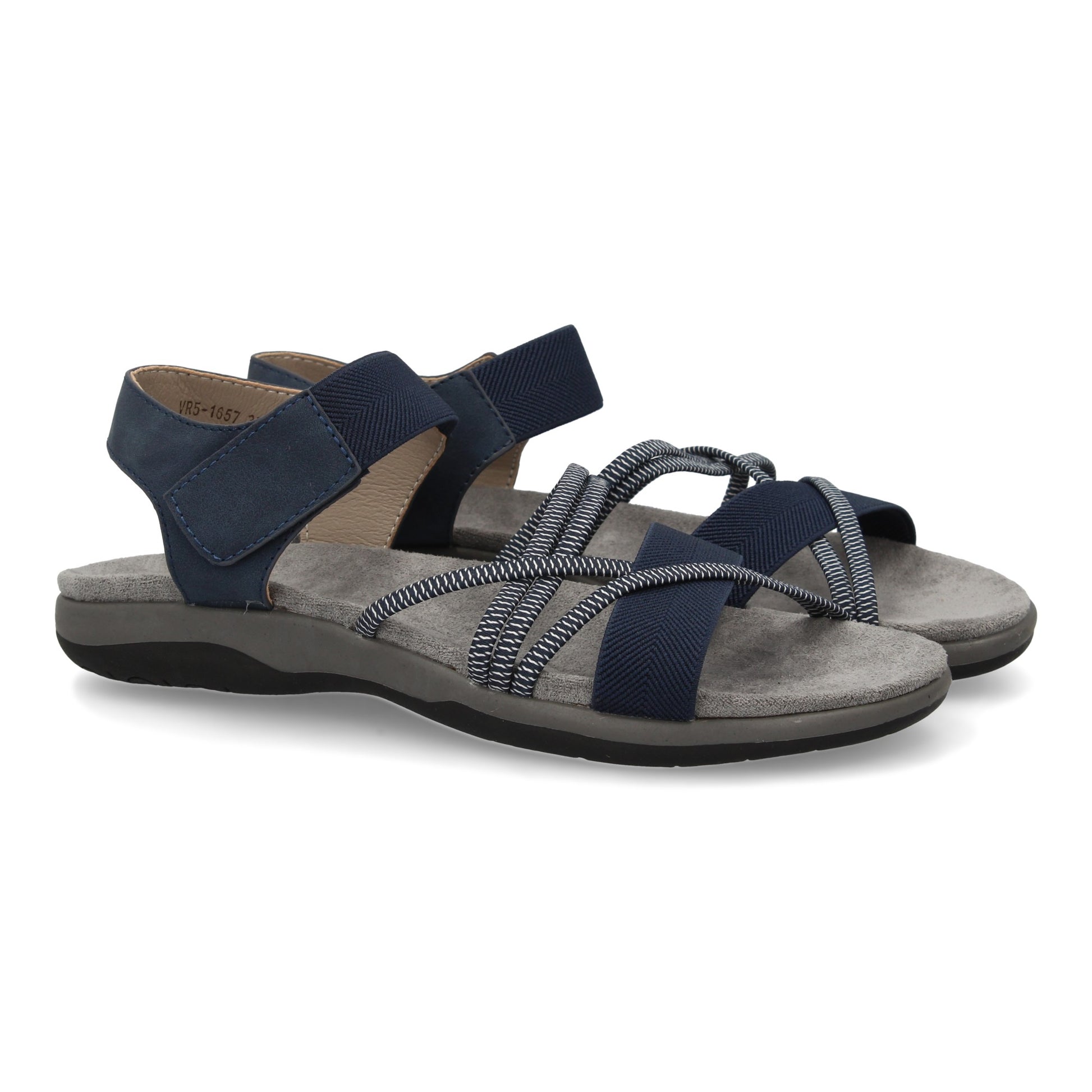 Sandalias planas de mujer color marino, con tiras elásticas cruzadas y cierre de velcro.