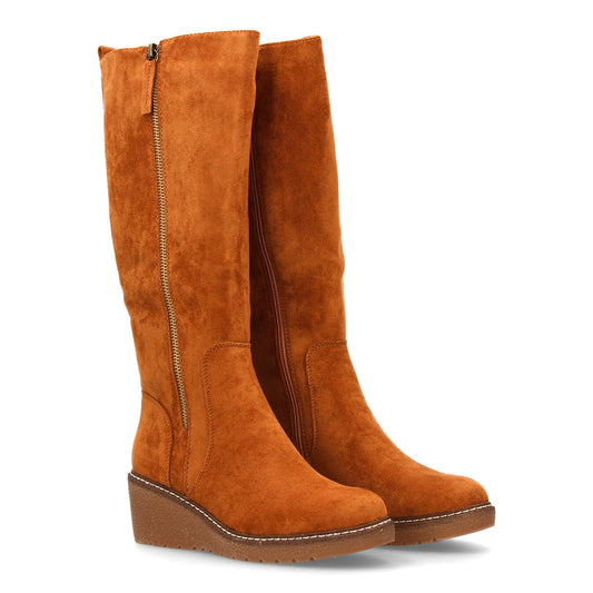Bota de caña alta de mujer color camel, elegante, con cuña y suela dentada. Cierre de cremallera.