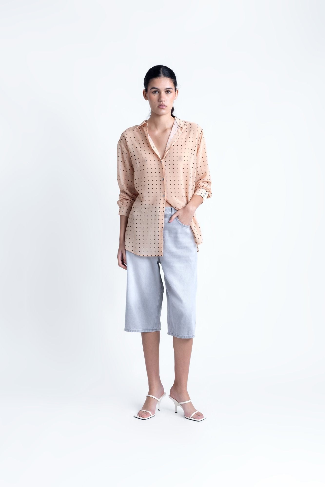 Blusa semitransparente para mujer en color beige con estampado clásico de lunares, botones frontales y mangas largas.