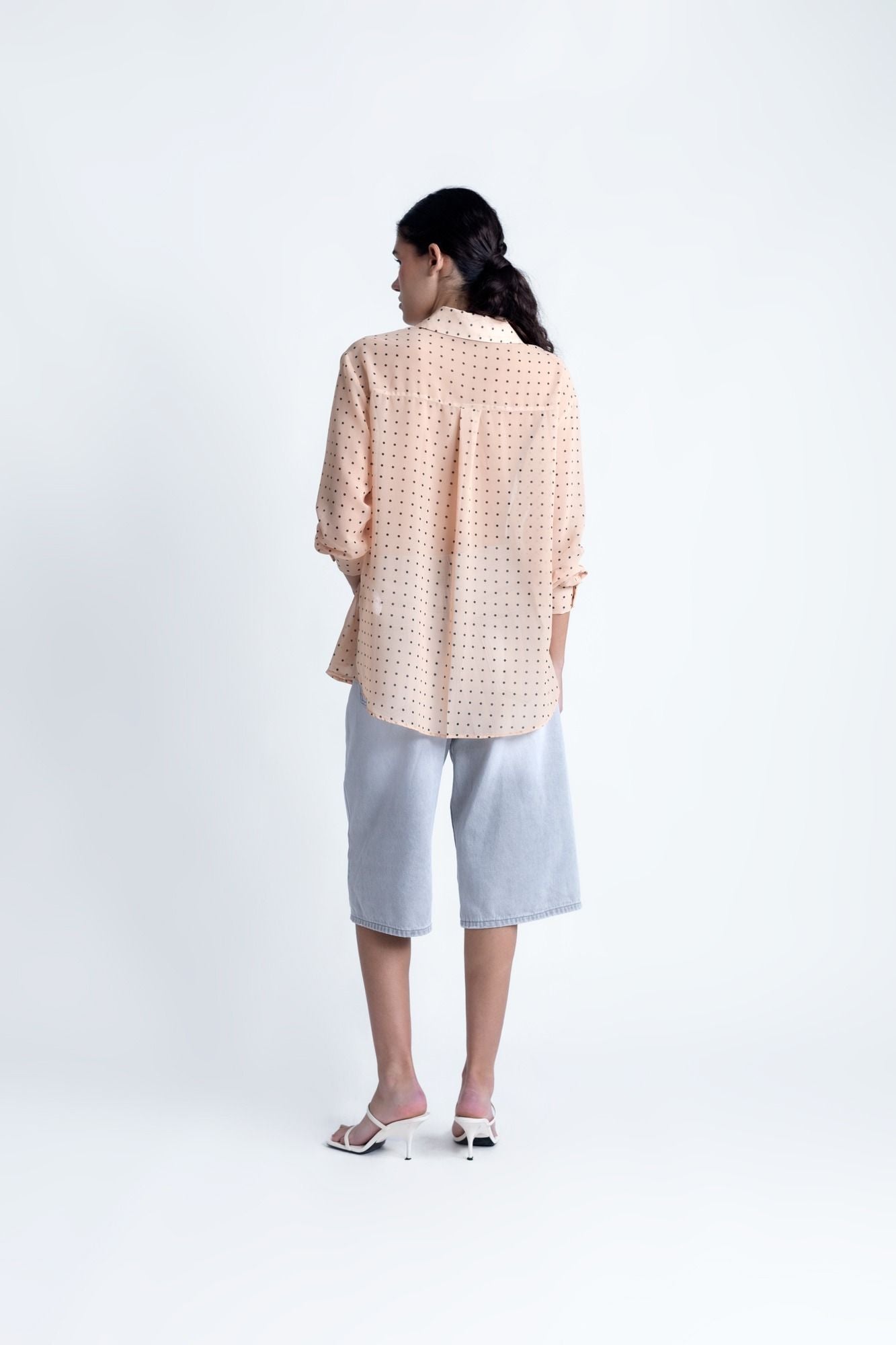 Blusa semitransparente para mujer en color beige con estampado clásico de lunares, botones frontales y mangas largas.