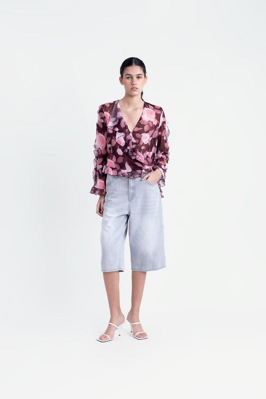 Blusa estampada con volantes en (especificar zona) y tejido fluido.