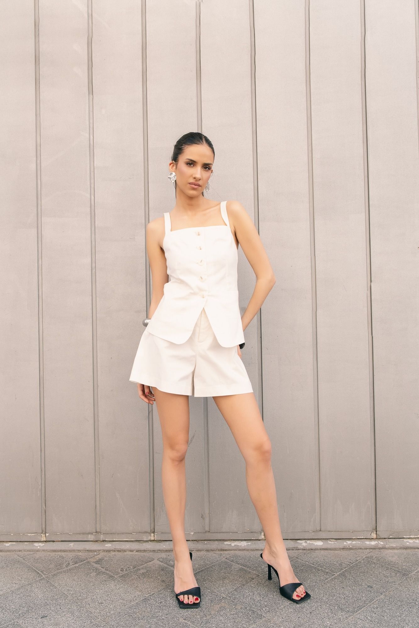 Chaleco sastre negro de tirantas con escote pico y botonadura frontal. Cierre ajustable en la espalda. Ideal para looks de oficina.