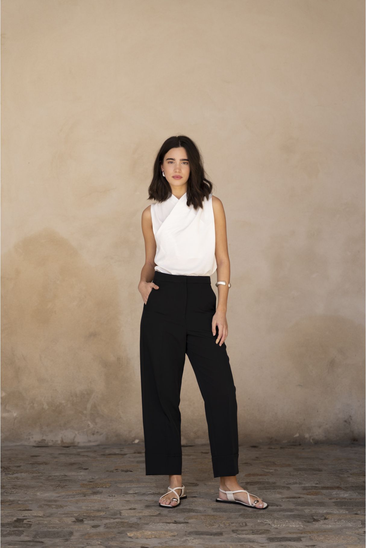 Blusa cruzada sin mangas para mujer en color crudo, con escote en V envolvente y silueta fluida satinada.