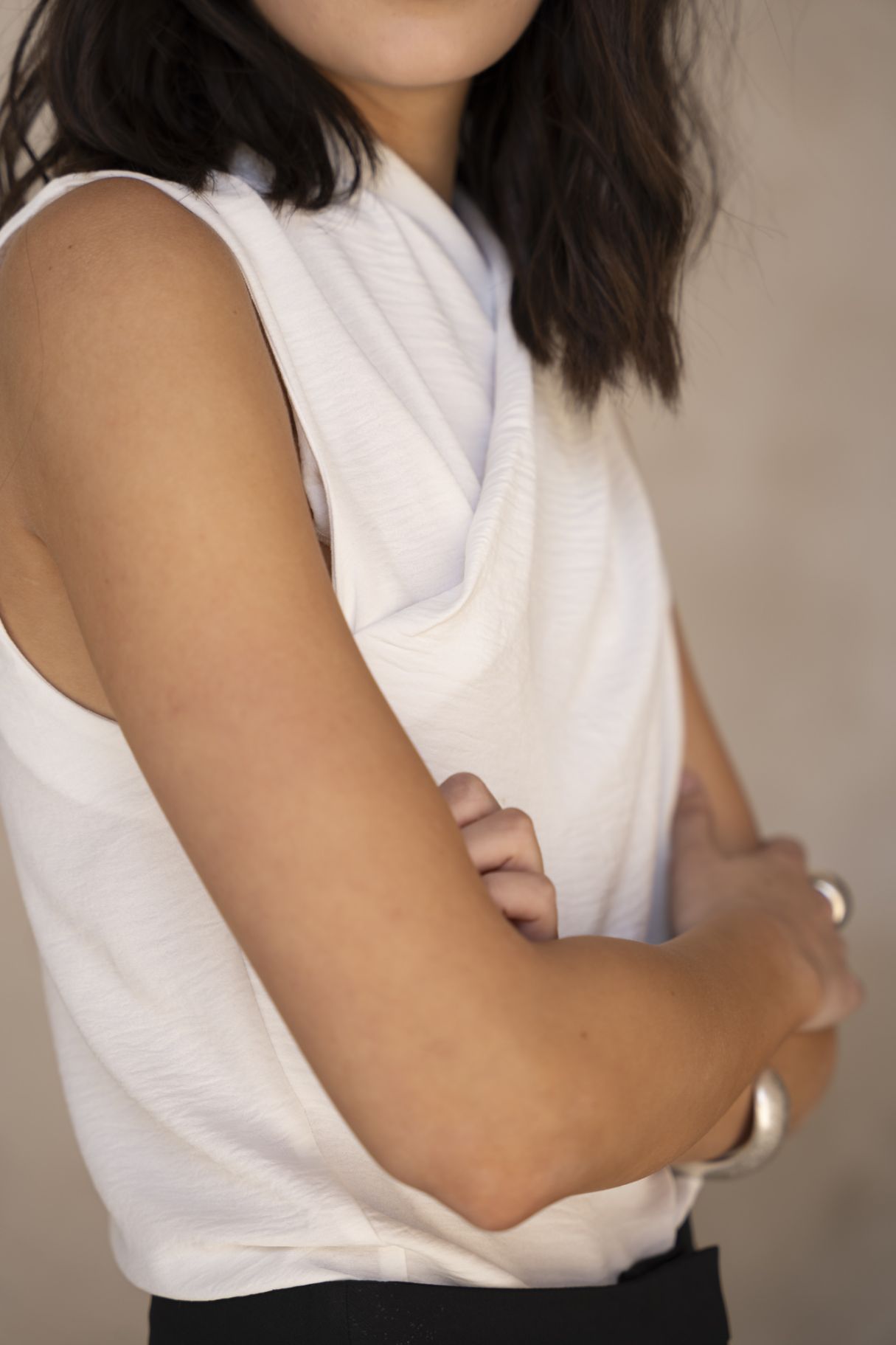 Blusa cruzada sin mangas para mujer en color crudo, con escote en V envolvente y silueta fluida satinada.