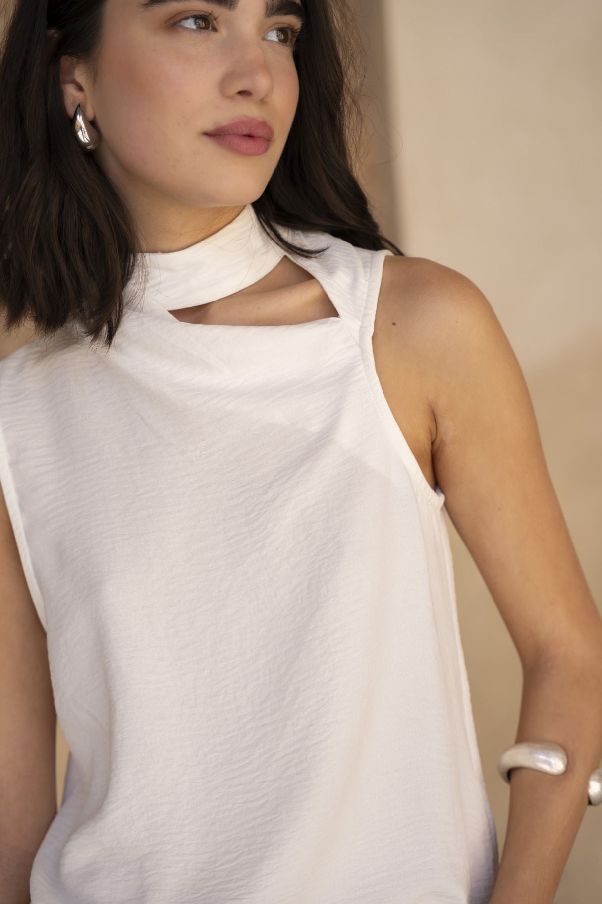Blusa elegante para mujer en color crudo con cuello de tortuga, hombros descubiertos estilo cut out y tejido plisado.