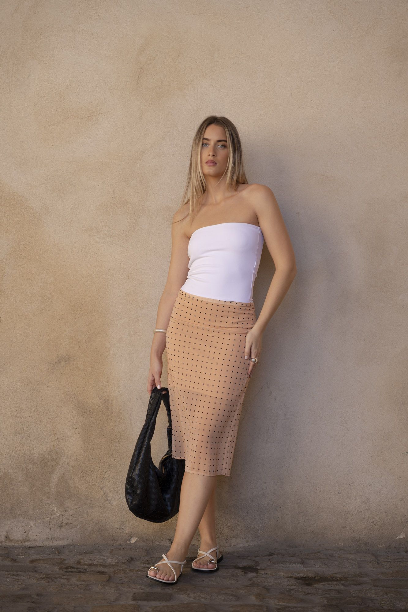 Falda midi de corte lápiz para mujer en color beige con estampado de lunares y abertura lateral para mayor movimiento.