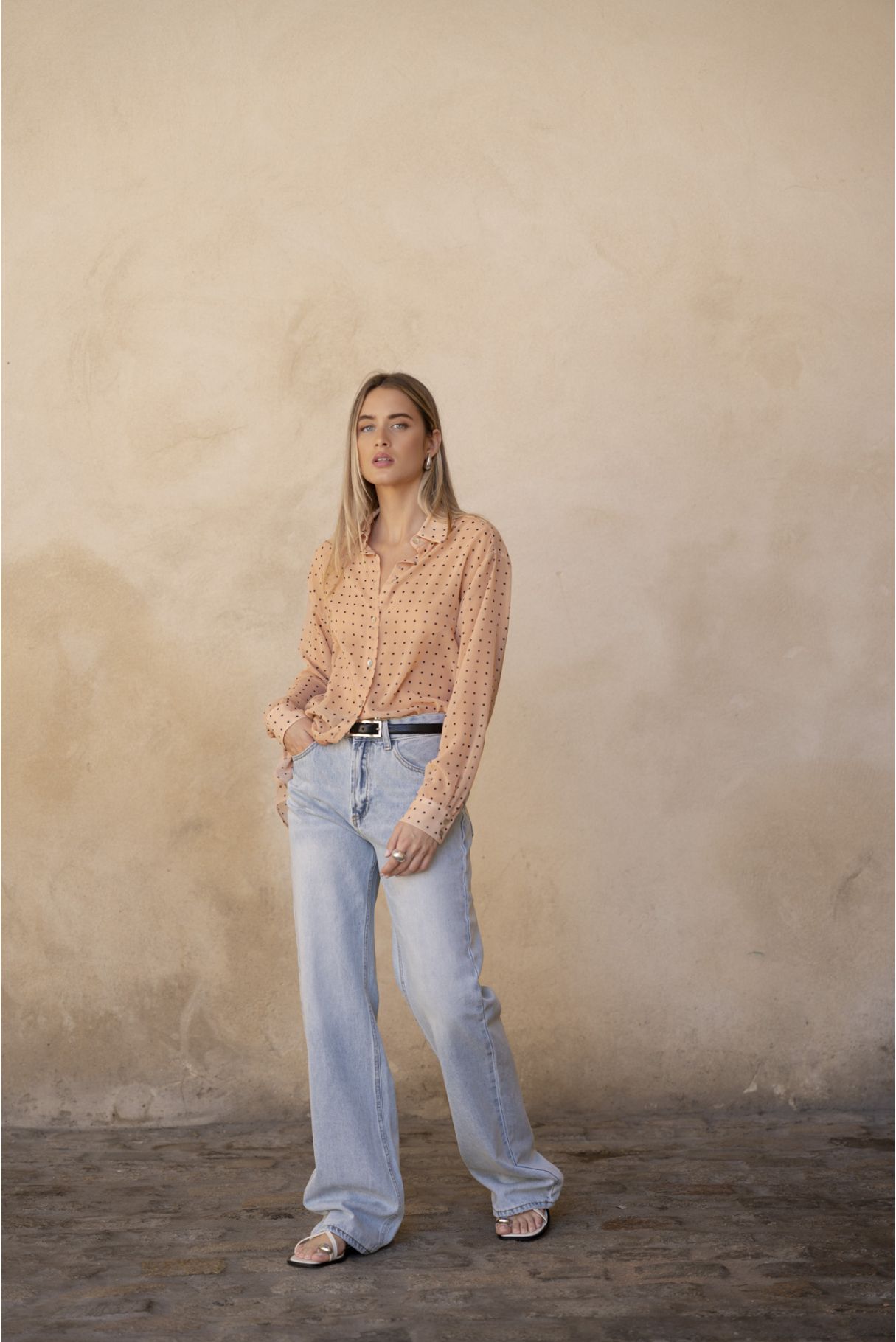 Blusa semitransparente para mujer en color beige con estampado clásico de lunares, botones frontales y mangas largas.