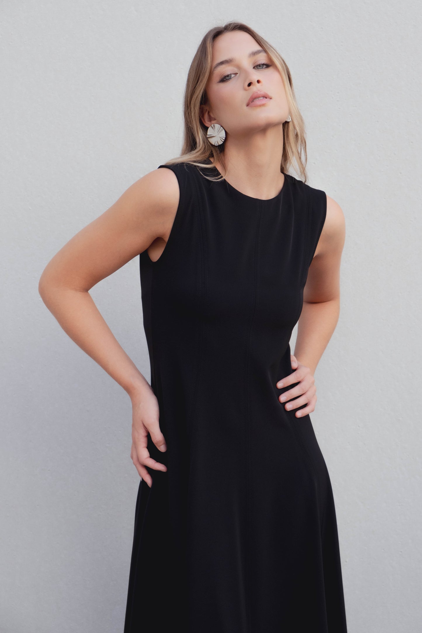 Vestido midi negro de corte minimalista con bajo de vuelo en nesgas