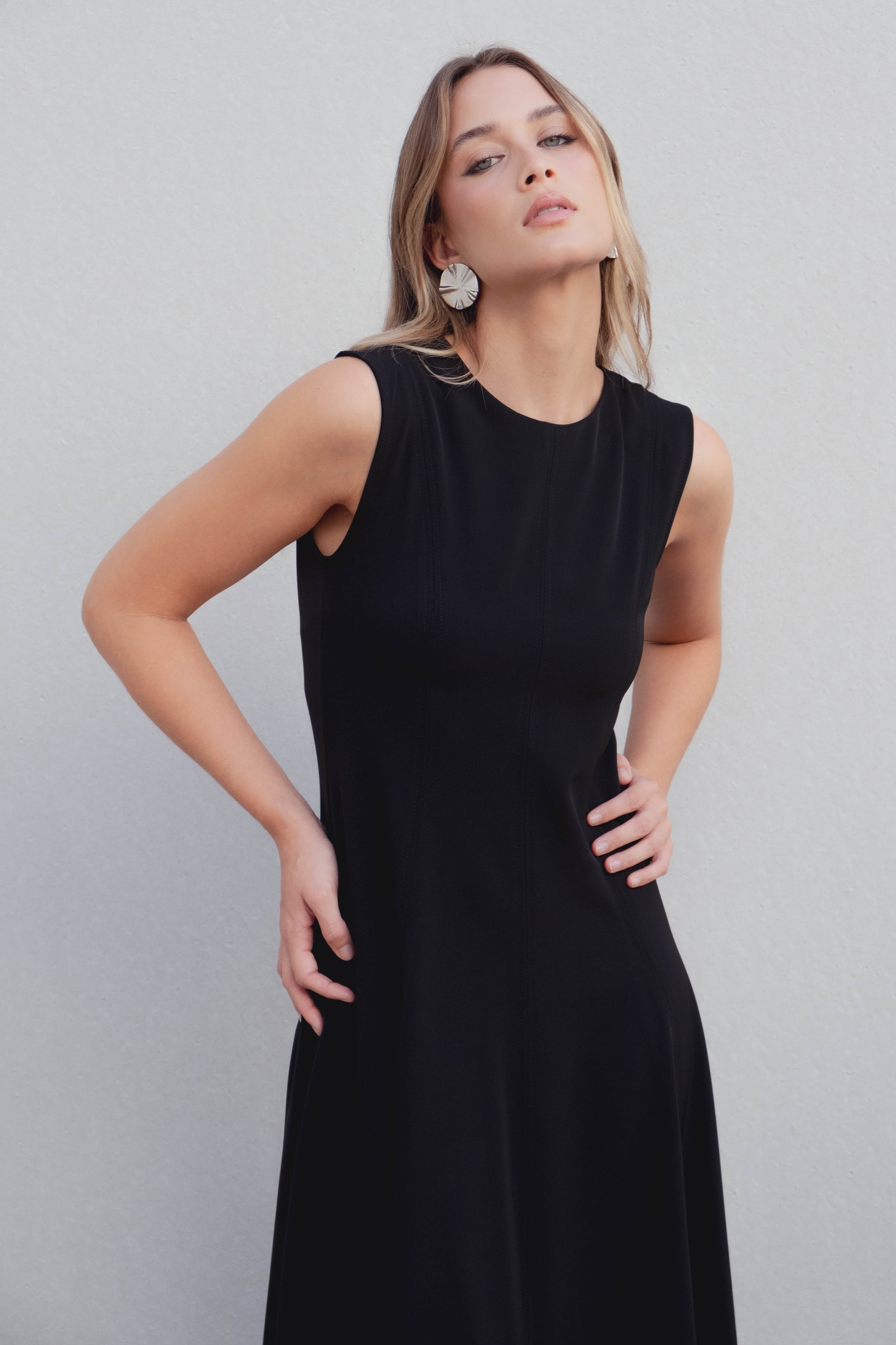 Vestido midi negro de corte minimalista con bajo de vuelo en nesgas