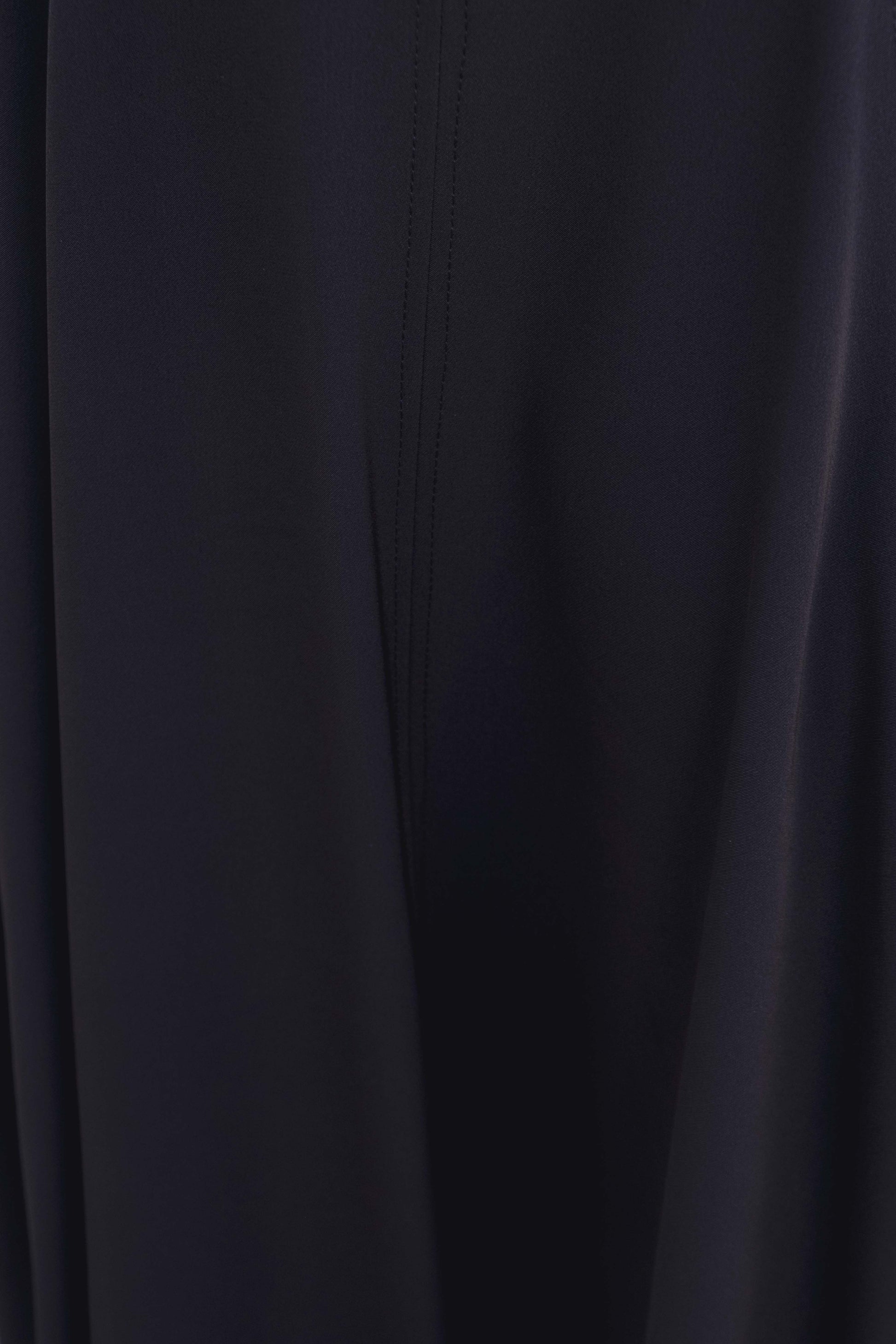 Vestido midi negro de corte minimalista con bajo de vuelo en nesgas