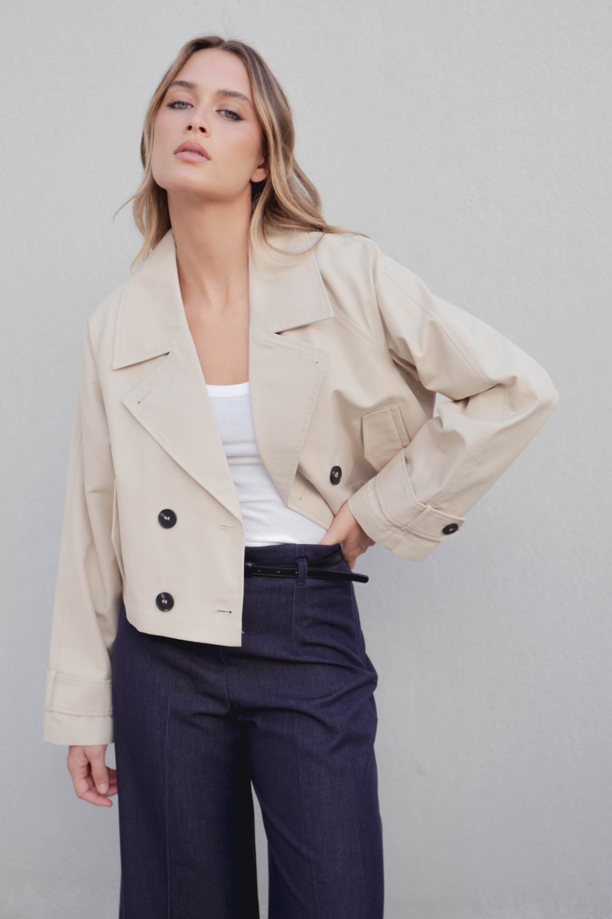 Gabardina corta (crop) de mujer, color neutro. 100% Poliéster. Diseño Made in Spain.