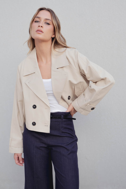 Gabardina corta (crop) de mujer, color neutro. 100% Poliéster. Diseño Made in Spain.