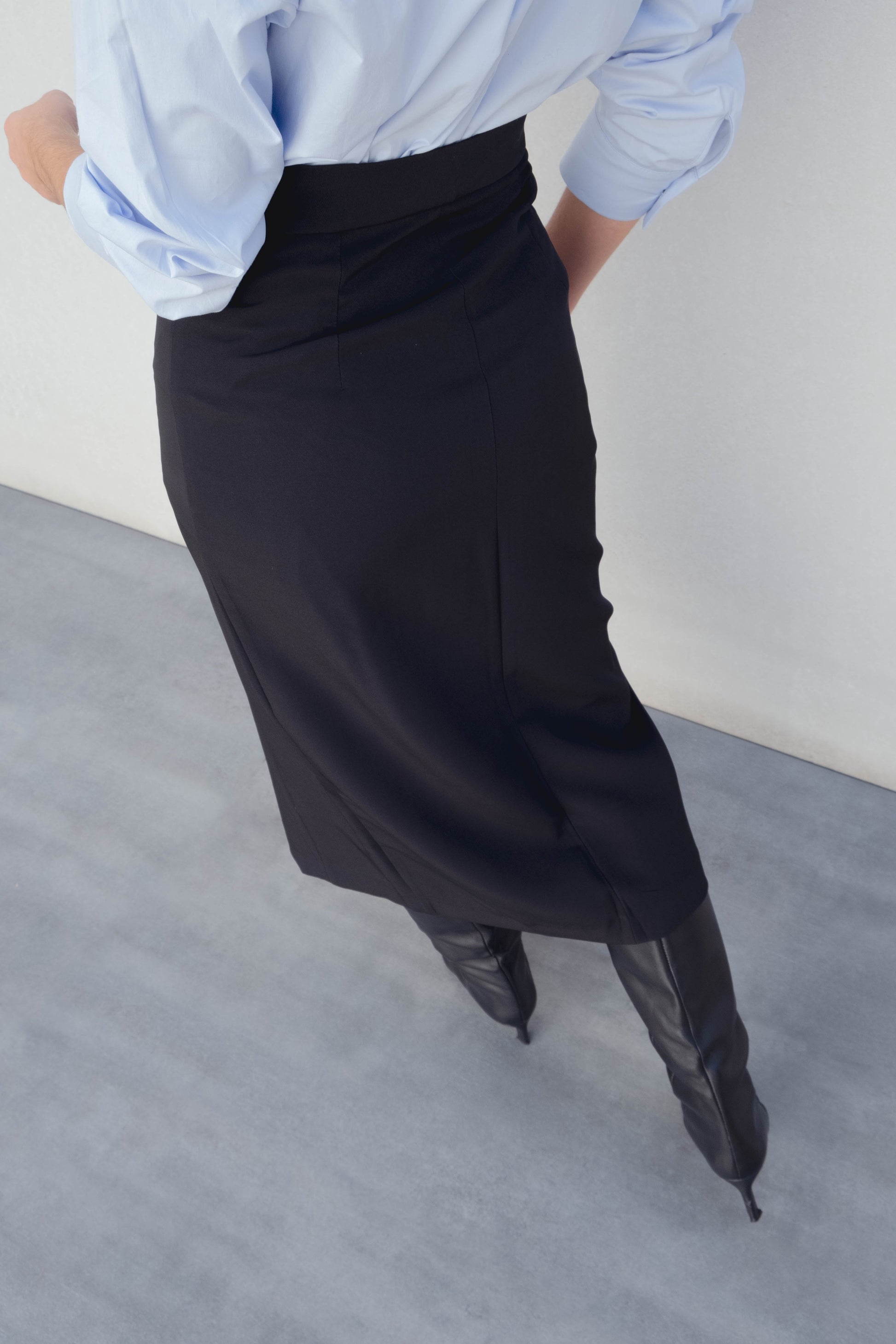 Falda midi de tubo elástica en color negro con abertura lateral en el bajo