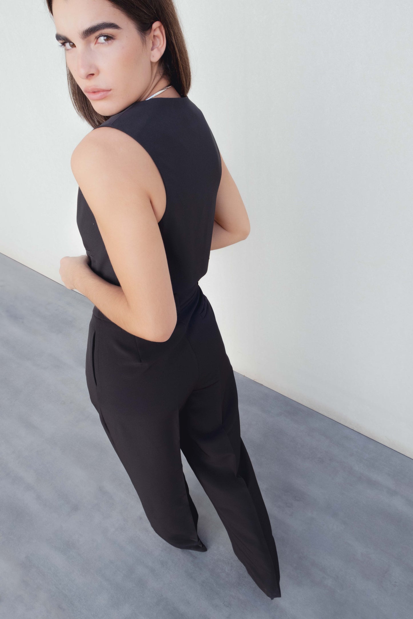 Chaleco sastre corto para mujer en color negro, de corte ajustado al cuerpo con escote en V y botones delanteros.
