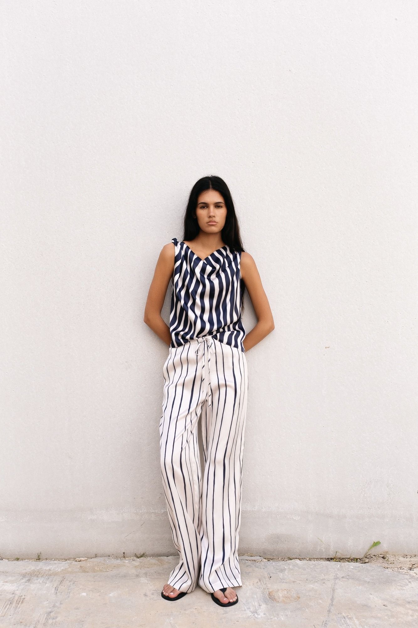 Pantalón fluido negro con estampado de rayas verticales. Cintura elástica y tejido ligero. 100% Viscosa. Diseño Made in Spain.